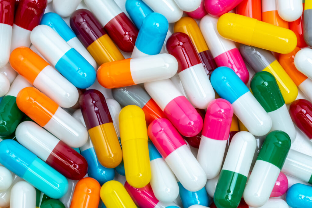 Colorful capsule pills. Pharmaceutical industry. Healthcare and medicine background. Pharmaceutics concept. Antibiotic drug resistance. Pink, white, orange, red, green, blue, and gray capsule pills.